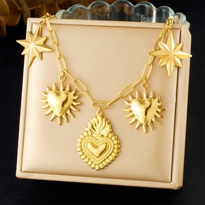 Gold plated stainless steel necklace with sun heart and star charms in a beige jewelry box