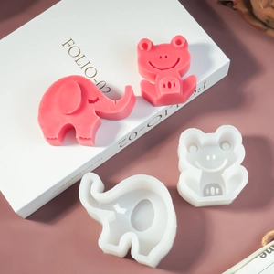 Detailweergave van olifant en kikker siliconen mallen met roze kaars voorbeelden erop