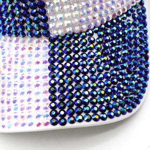 Macro shot of blue and iridescent rhinestones on a white fabric baseball cap detail
