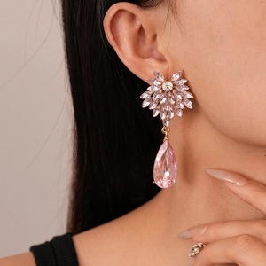 Close-up of pink crystal teardrop earrings with floral stones worn by a model