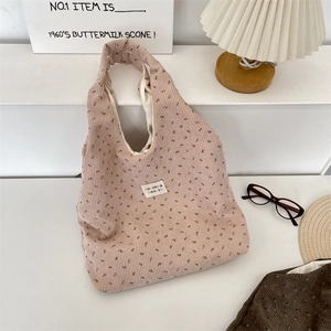 Détail du sac cabas en velours côtelé fleuri montrant la texture et l'étiquette