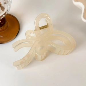 Detail of translucent cream butterfly hair claw clip with pearlescent glitter finish