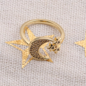 Chic gold moon and star open ring with sparkling cubic zirconia on a white textured backdrop