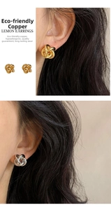 Close-up detail of eco-friendly copper knotted stud earrings in gold and silver finish