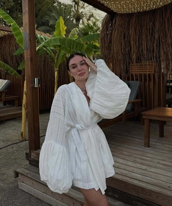 Détail de la robe courte blanche à manches lanternes et tissu texturé de style vacances