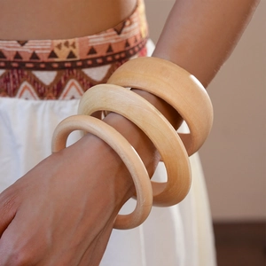 Detailed view of three-piece natural wood bangles with unique organic grain textures