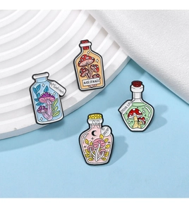 Detail of four mushroom theme potion bottle enamel pins with Made of Magic engraving