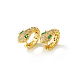 Golden snake hoop earrings with pavé crystals and green gemstone eyes on white backdrop