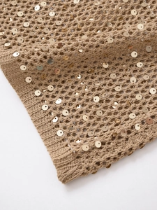 Détail de tricot ajouré avec paillettes dorées sur un débardeur sans manches kaki