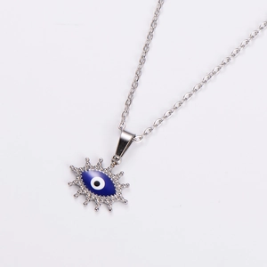 Detailed view of silver oval evil eye pendant with blue enamel and steel chain