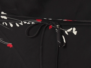 Détail d'imprimé floral rouge sur soie noire avec fine ficelle de serrage assortie