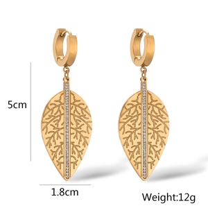 Dettaglio orecchini a foglia oro da 5cm con venature e strass bianchi brillanti