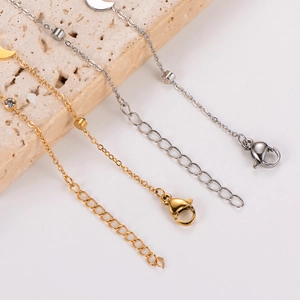 Close-up of gold and silver moon necklaces with cubic zirconia on a stone surface