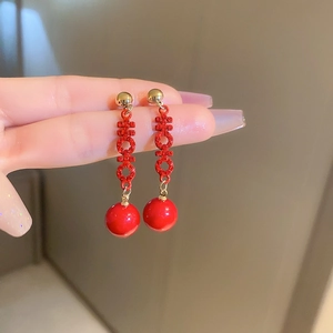 Detail of red Chinese wedding earrings with gold stud and sparkling rhinestone xi characters