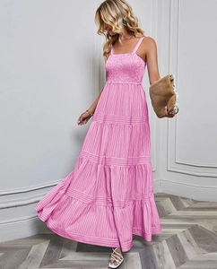 Close-up of smocked bodice and tiered pink striped maxi dress with vertical patterns