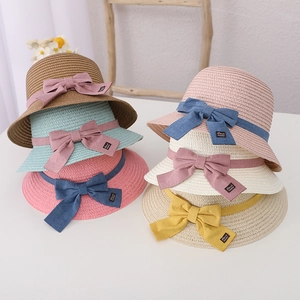 Detail of diverse colors of girls straw hats with handmade bows for sun protection