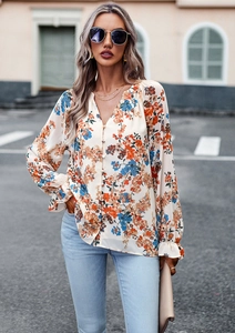 Dettaglio camicia floreale a maniche lunghe con scollo a V e bottoni su beige