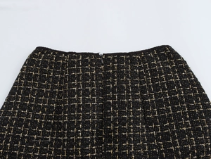 Dettaglio gonna in tweed nero con fili dorati e cerniera posteriore a scomparsa