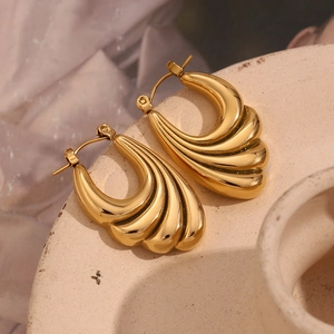Detailed close-up of 18K gold plated stainless steel wave textured hoop earrings