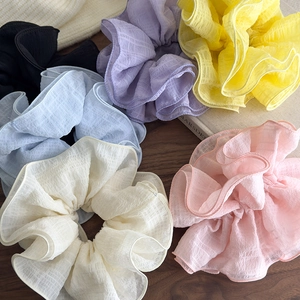 Set of six colorful ruffled chiffon oversized hair scrunchies on a wooden surface