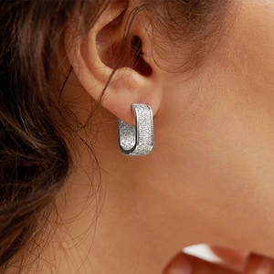Close-up of silver U-shaped hoop earrings with micro-pave cubic zirconia on model
