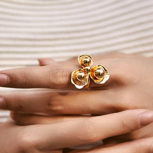 Macro shot of 18K gold plated floral ring featuring brushed texture and center beads