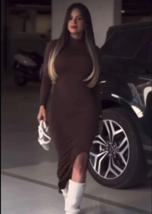Detail view of a long sleeve dark brown bodycon dress with mock neck and side leg slit