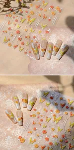 Detailed view of 3D embossed nail art stickers with orange roses and yellow butterflies