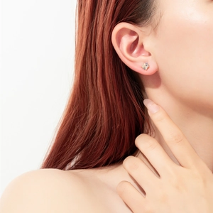Detail view of 925 sterling silver studs with colorful zircon cluster on model's ear