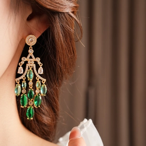 Detail of green teardrop earrings with gradient crystals on a female model