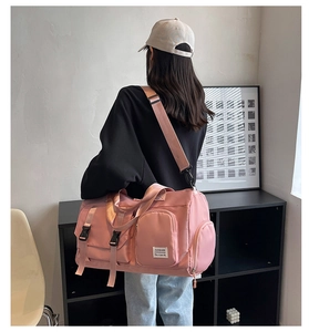Detail view of pink fitness travel bag with adjustable shoulder strap on a model back