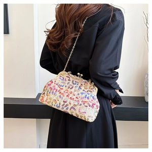 Colorful woven evening bag with leopard pattern shown as a stylish crossbody on model