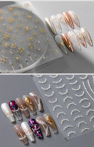 Macro-opname van 5D 3D goudsterren en witte parel nagelstickers op een grijze achtergrond