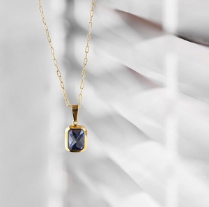 Dettaglio macro della collana a graffetta placcata oro 18K con gemma blu rettangolare