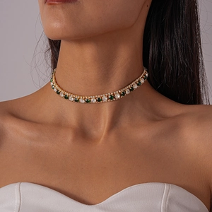 Detail shot of vintage choker necklace with green emerald-cut stones and clear crystals