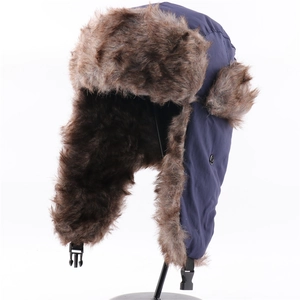 Detail of waterproof trapper hat featuring blue fabric and brown faux fur lining with buckle