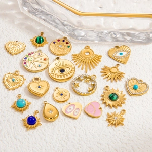 Detailed overhead view of assorted gold charms including evil eye and heart shapes