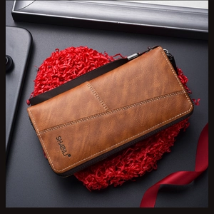 Detailed shot of brown long zip wallet with leather texture and wrist strap in gift box