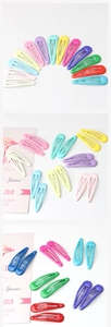 Macro shot of colorful candy-colored metal teardrop hair clips with snap buckle design