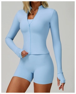 Detail of light blue slim zip-up running jacket with thumbholes and high-waist yoga shorts