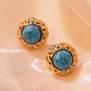Detail of vintage turquoise-style stud earring with golden lattice engraved borders