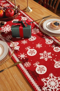 Close-up of red Christmas table runner with white snowflake and bauble jacquard patterns