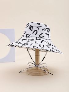 Detail of white wide brim sun hat with black heart graffiti pattern and chin strap