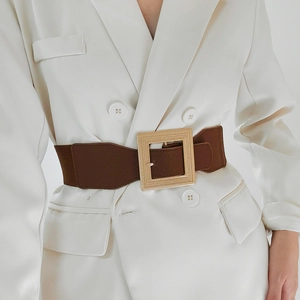 Detail of a brown elastic waist belt with a large golden square buckle for women