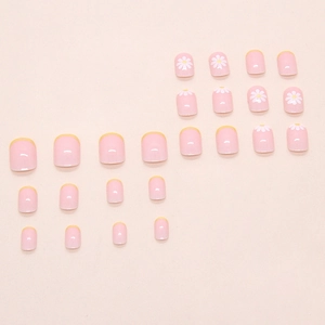 Unghie finte French gialle con decorazioni a margherite bianche su base rosa
