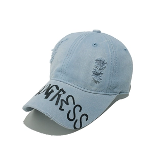 Close-up of light blue denim baseball cap showing distressed details and PROGRESS print
