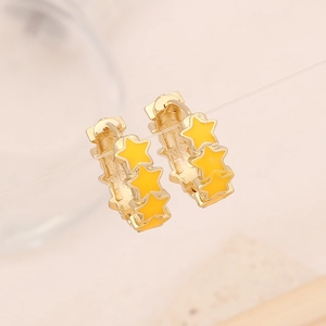 Detail of gold star drop earrings featuring three yellow enamel stars hanging on a line