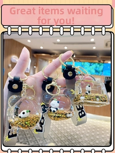 Gros plan de porte-clés panda liquide avec paillettes d'étoiles dorées et formes variées