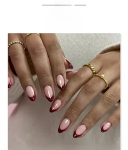 French tip almond press-on nails in burgundy and nude pink on hands with rings