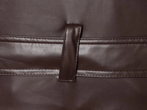 Gros plan sur le passant de ceinture en cuir à double couture du trench marron